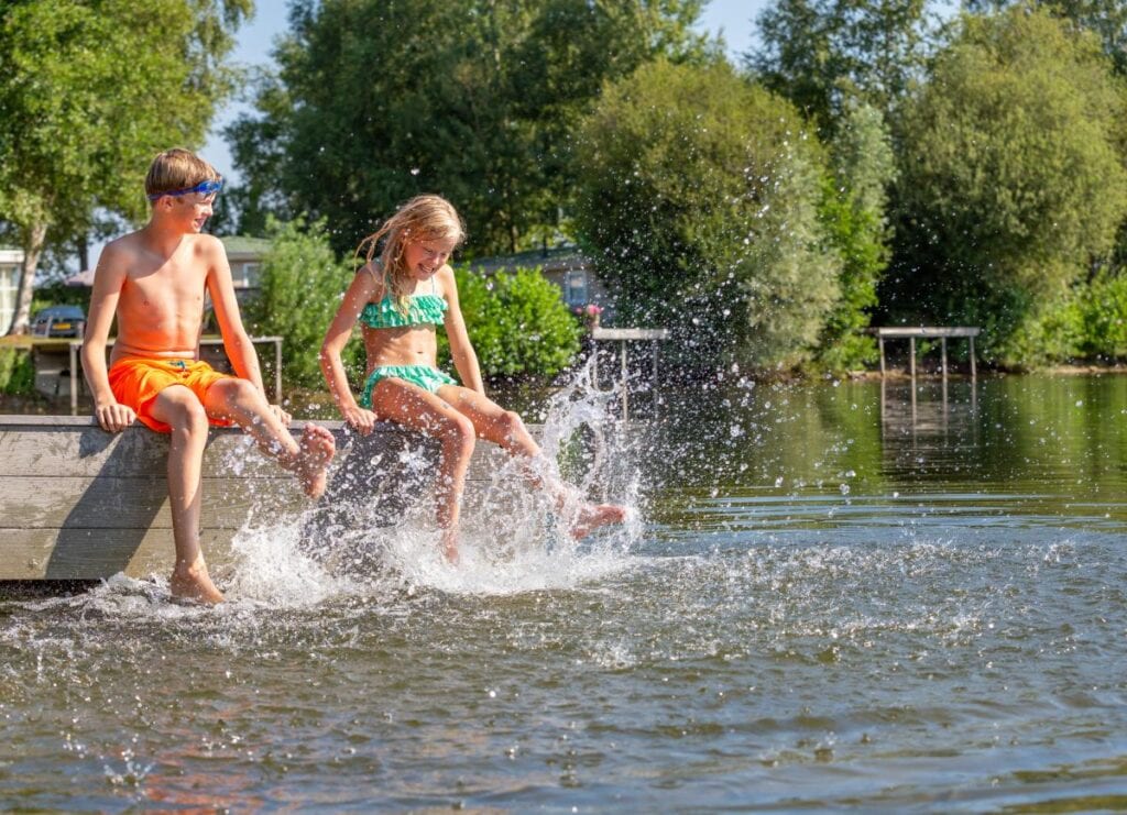 Jongen en meisje aan de rand van het natuurbad van Roompot Recreatiepark De Tolplas in Hoge Hexen in Overijssel