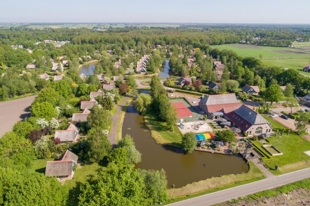 Vogelvluchtfoto met huisjes en speeltuin van Villapark de Weerribben in Paasloo in Overijssel