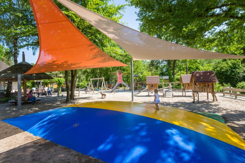 Kinderen springen op de airtrampoline van het kindvriendelijke vakantiepark Landal Twenhaarsveld in Holten in Overijssel