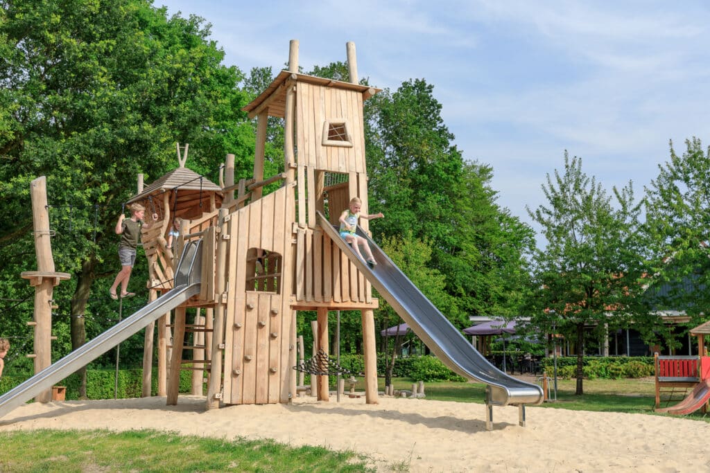 Kinderen spelen op de klimtoren in de speeltuin van Ardoer Recreatiepark Kaps in Tubbergen in Overijssel