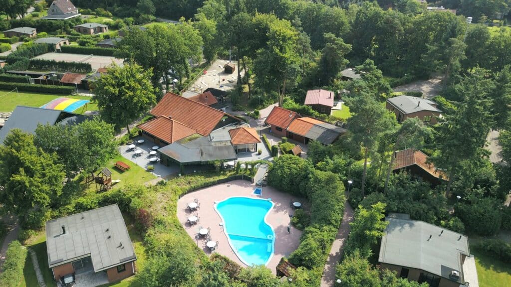 Overzicht van boven met vakantiehuisjes en het zwembad van het vakantiepark De Lindenberg in Holten in Overijssel