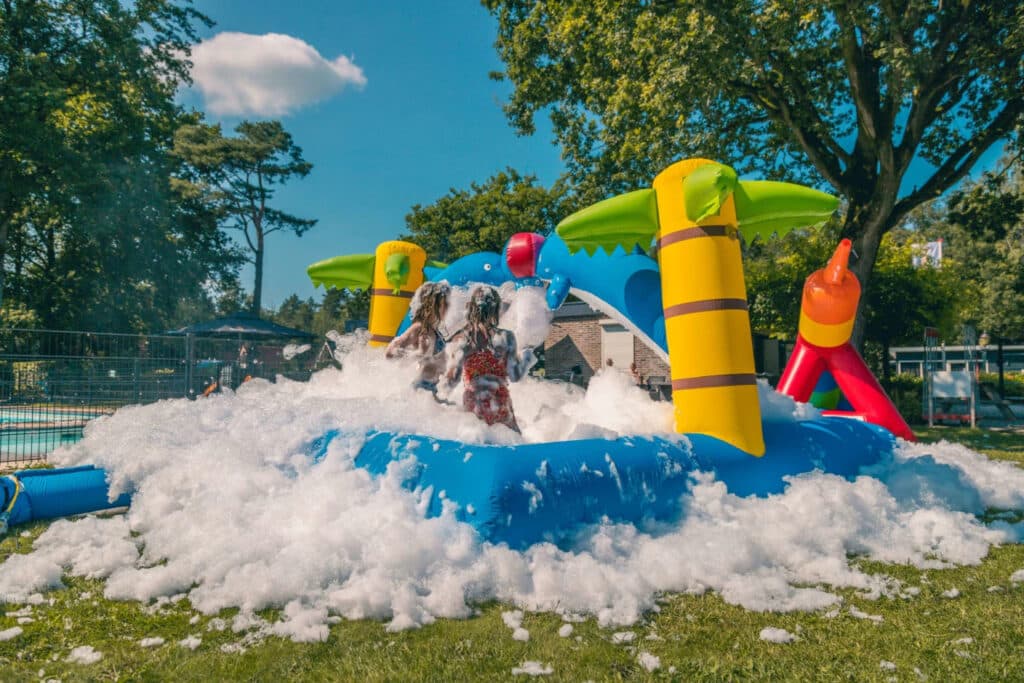 Kinderen spelen in schuim op springkussen op EuroParcs Reestervallei in IJhorst in Overijssel