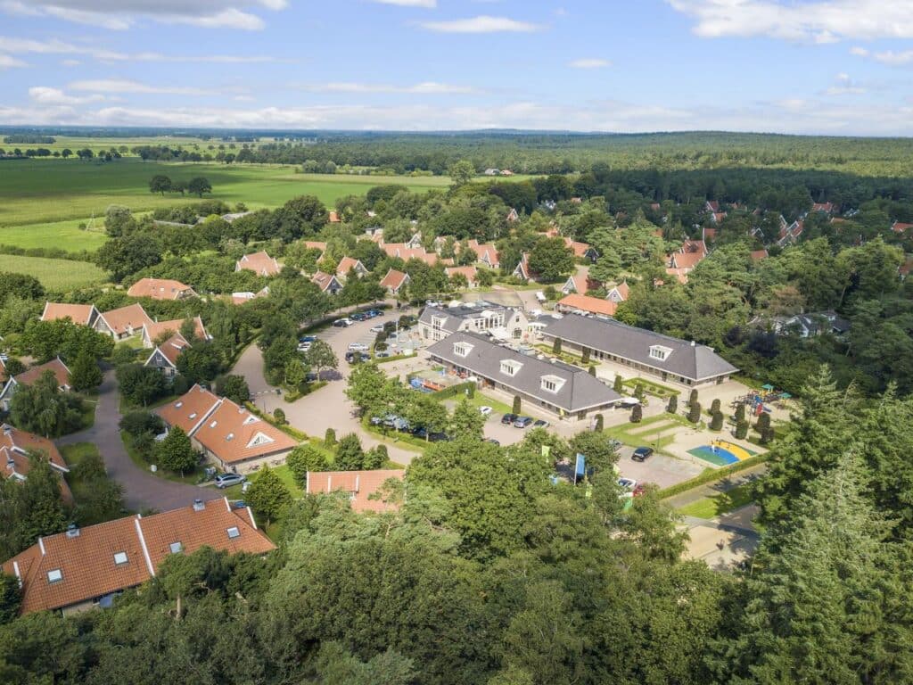 Vogelvlucht van vakantiehuisjes, de speeltuin en het hoofdgebouw van Landal Landgoed De Hellendoornse Berg in Haarle in Overijssel
