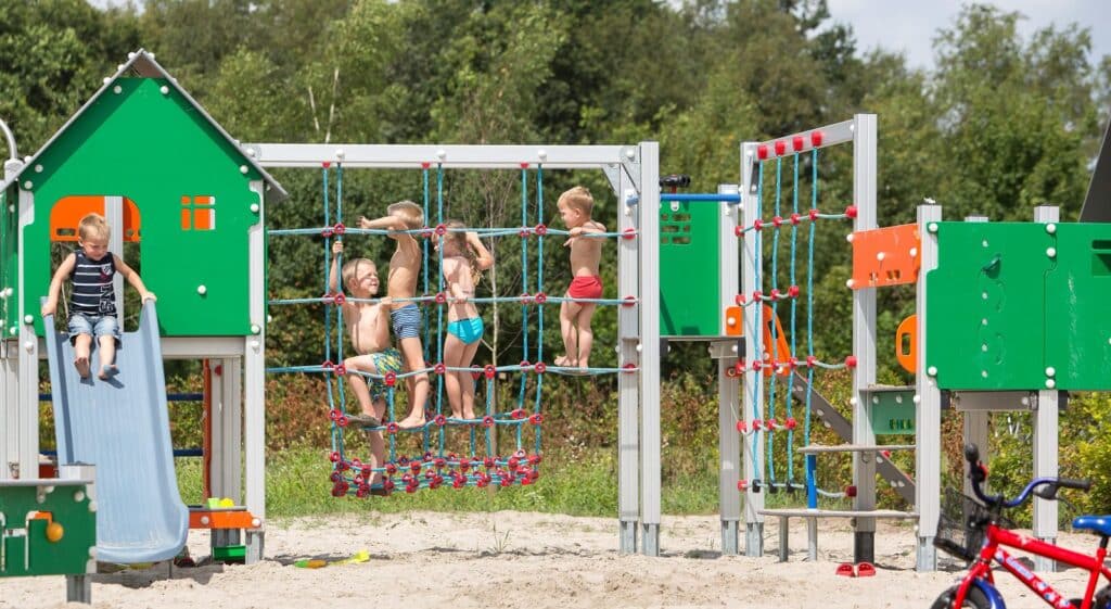 Kinderen spelen op het klimrek in de speeltuin van Vakantiepark 't Rheezerwold in Heemserveen in Overijssel